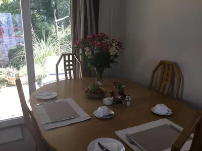 a wooden table with a vase of flowers on it at Ingleneuk Bed and Breakfast in Edinburgh