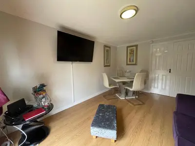 a living room with a table and a flat screen tv at HLA - KING COURT APARTMENT 2 in Motherwell