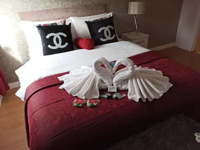 two swansrendered to look like hearts are sitting on a bed at HLA - KING COURT APARTMENT 2 in Motherwell