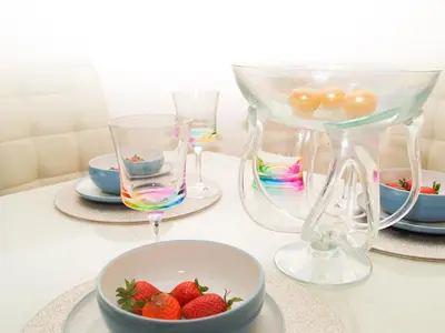 a table with a bowl of strawberries and wine glasses at HLA - KING COURT APARTMENT 2 in Motherwell