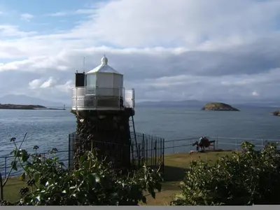 a lighthouse on the side of a body of water at Lagganbeg Guest House in Oban