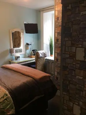 a bedroom with a bed and a sink and a mirror at Lagganbeg Guest House in Oban