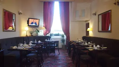 a dining room with tables and chairs and a window at Thistle Hotel in Edinburgh