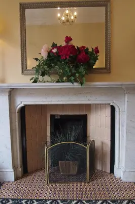a fireplace with a mirror and flowers on top at Thistle Hotel in Edinburgh