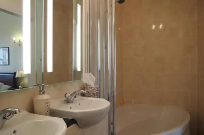 a bathroom with a sink and a shower and a tub at Thistle Hotel in Edinburgh