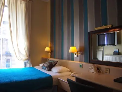 a hotel room with a bed and a mirror at Thistle Hotel in Edinburgh