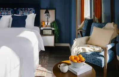 a bedroom with a bed and a bowl of oranges on a table at Heeton Concept Aparthotel Edinburgh Queen Street in Edinburgh
