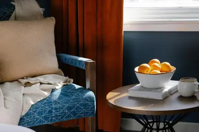 a bowl of fruit on a table next to a chair at Heeton Concept Aparthotel Edinburgh Queen Street in Edinburgh