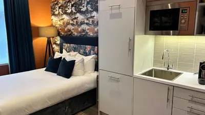 a small kitchen with a bed and a sink at Heeton Concept Aparthotel Edinburgh Queen Street in Edinburgh