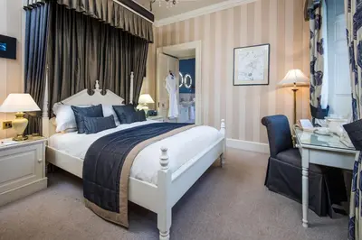a bedroom with a bed and a desk and a chair at Cringletie House in Peebles