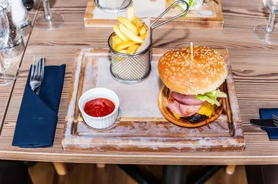 a plate with a sandwich and french fries on a table at Columba Hotel in Oban