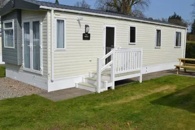 a mobile home with a staircase and a bench at Callander Woods Holiday Park in Callander