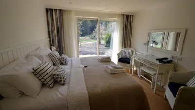 a bedroom with a bed with a desk and a window at Bridge of Orchy Hotel in Bridge of Orchy
