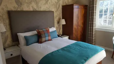 a bedroom with a bed with blue and white at Bridge of Orchy Hotel in Bridge of Orchy
