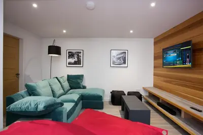 a living room with a couch and a tv at LOCH TAY HIGHLAND LODGES and GLAMPING PARK in Morenish