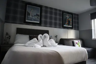 two swans in towels sitting on a bed at Harbourside Hotel in Irvine