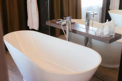 a bathroom with a white tub and a sink at The Redhurst Hotel Glasgow in Giffnock