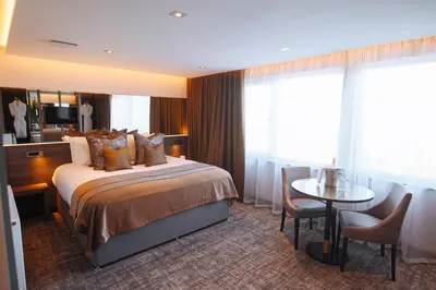 a hotel room with a bed and a table at The Redhurst Hotel Glasgow in Giffnock