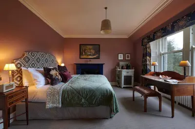 a bedroom with a bed and a desk and a window at Cromlix in Kinbuck