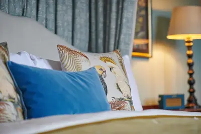 a bed with blue and white pillows and a lamp at Cromlix in Kinbuck