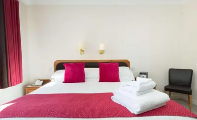 a bedroom with a bed with red and white towels on it at Pitbauchlie House Hotel - Sure Hotel Collection by Best Western in Dunfermline