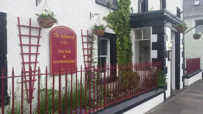 a red sign on the side of a building at Balmoral Hotel in Moffat