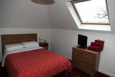 a bedroom with a bed and a tv on a dresser at Balmoral Hotel in Moffat