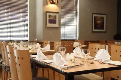a dining room with a table and chairs with wine glasses at Argyll Hotel in Dunoon