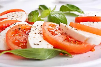 a plate of food with tomatoes and basil on it at Argyll Hotel in Dunoon