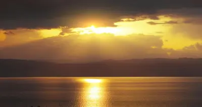 a sunset over a body of water with the sun setting at Argyll Hotel in Dunoon