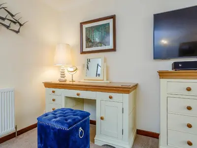 a room with a desk with a lamp and a blue stool at Ard Taigh in Stron-fearnan