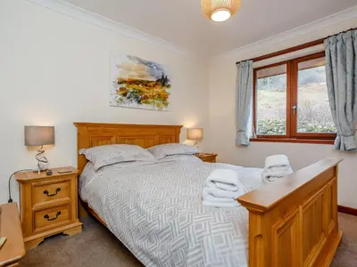 a bedroom with a bed and a desk and a window at Ard Taigh in Stron-fearnan