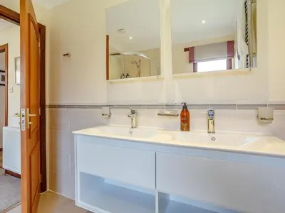 a bathroom with a white sink and a mirror at Ard Taigh in Stron-fearnan
