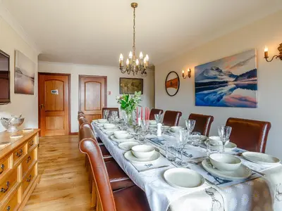 a dining room with a long table and chairs at Ard Taigh in Stron-fearnan