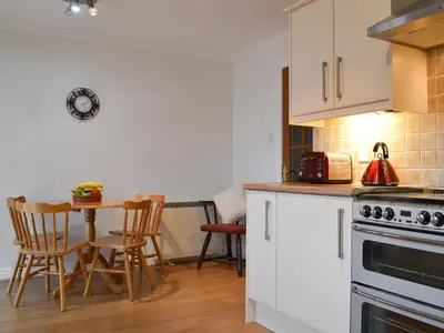 a kitchen with a table and a stove top oven at Riverside in Kilmelford