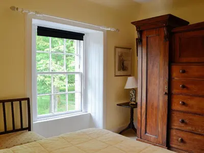 a bedroom with a bed and a window and a dresser at The Old Stables in Sorn