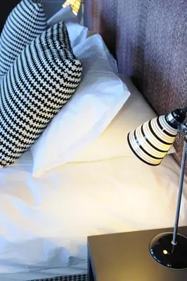 a bed with pillows and a lamp on a table at B+B Edinburgh in Edinburgh