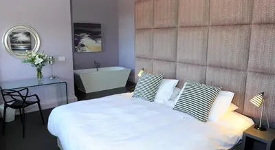 a bedroom with a bed and a bath tub at B+B Edinburgh in Edinburgh