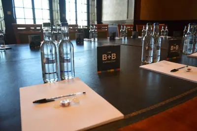 a table with bottles of water and a pen on it at B+B Edinburgh in Edinburgh