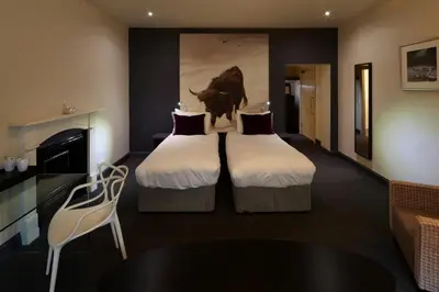 a hotel room with two beds with a cow on the wall at B+B Edinburgh in Edinburgh