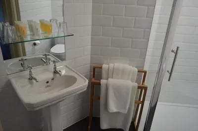 a white bathroom with a sink and a shower at B+B Edinburgh in Edinburgh
