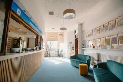 a waiting room with two green chairs and a counter at Glasgow Youth Hostel in Glasgow