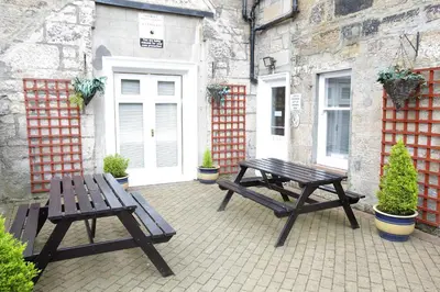 two picnic tables sitting in front of a building at Embassy Apartments in Glasgow