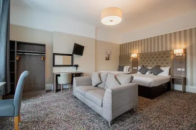 a hotel room with a bed and a couch at Embassy Apartments in Glasgow