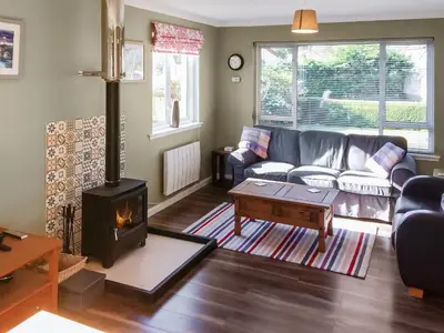 a living room with a couch and a wood stove at Achnaha in Ardentinny