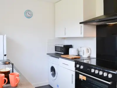 a kitchen with a stove and a washer and dryer at Achnaha in Ardentinny