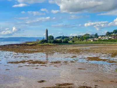 a lighthouse on the shore of a body of water at Largs Brisbane Cottage in Largs