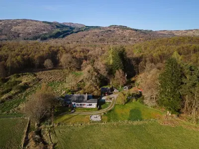 an aerial view of a house on a hill at Strathcashel Cottage in Rowardennan