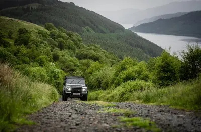 a jeep driving down a dirt road on a hill at JA Mar Hall Scotland in Bishopton