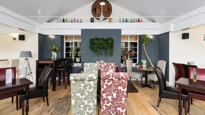 a salon with tables and chairs and a waiting room at Killin Hotel in Killin